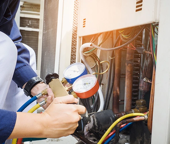 Worker inspecting boiler with gauges, representing reliable and professional boiler repair services.